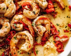Image of a white plate with Chili Garlic Butter Shrimp in a buttery sauce